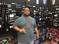 Charles Thomas surrounded by some of the goods in his shop